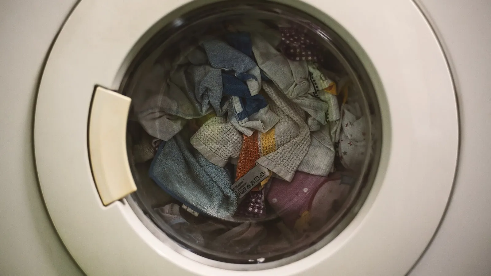 A front-loading washing machine drum filled with laundry